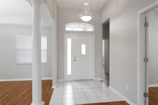 foyer entrance with light hardwood / wood-style flooring and ornate columns