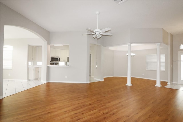 unfurnished living room featuring ceiling fan, decorative columns, and light hardwood / wood-style flooring