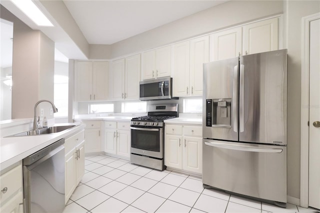 kitchen with sink, white cabinetry, stainless steel appliances, and light tile patterned floors