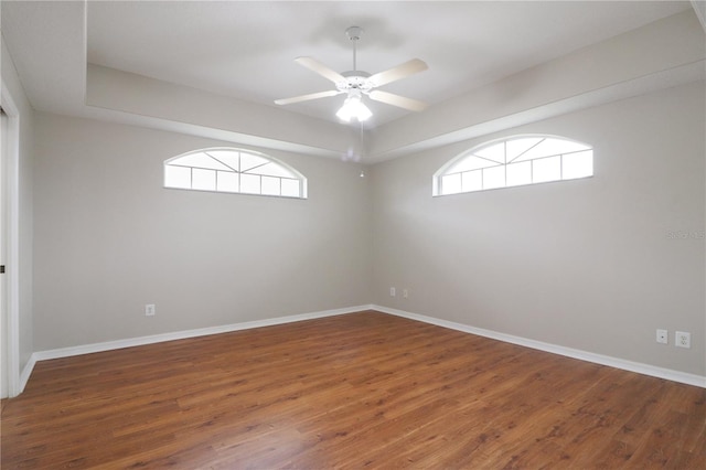 empty room featuring dark hardwood / wood-style floors, a healthy amount of sunlight, and ceiling fan