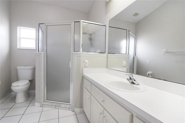 bathroom featuring toilet, vanity, tile patterned floors, and a shower with door