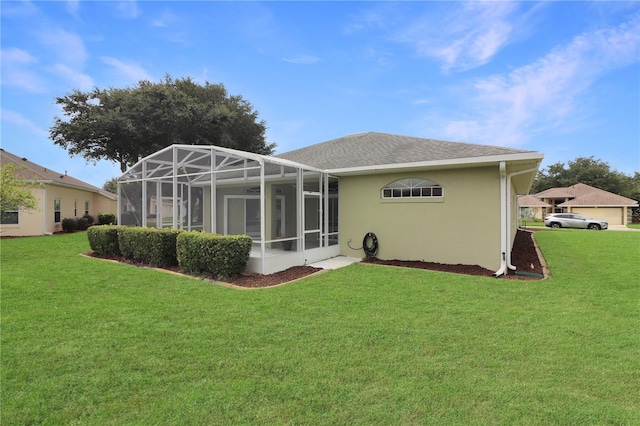 back of property with a yard and glass enclosure