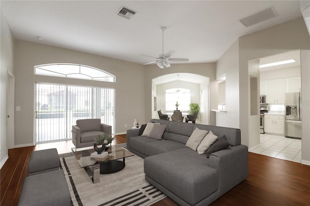 living room featuring light hardwood / wood-style floors, lofted ceiling, and ceiling fan