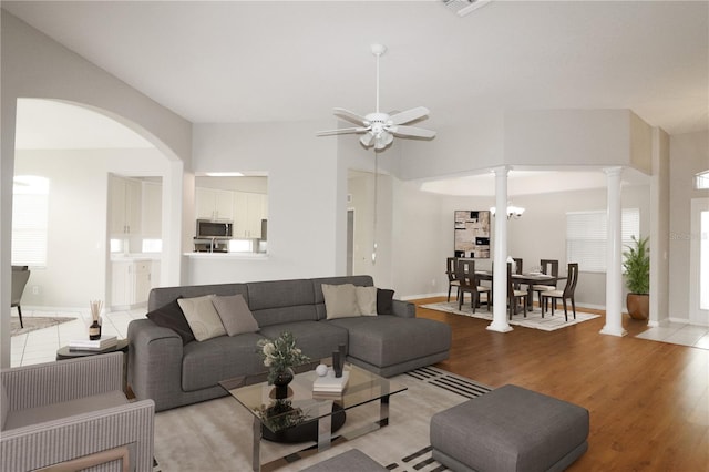 living room with ornate columns, light hardwood / wood-style floors, and ceiling fan