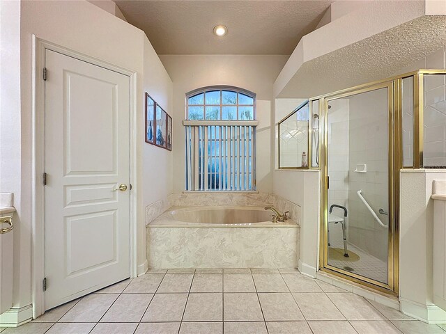 bathroom featuring plus walk in shower, a textured ceiling, and tile patterned floors