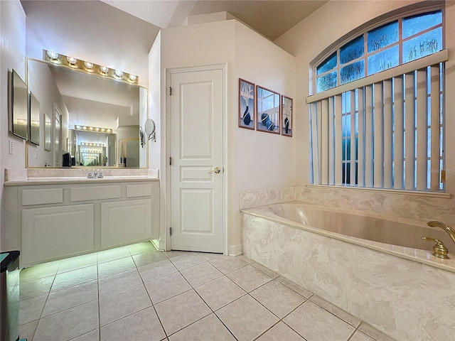 bathroom with vanity, a relaxing tiled tub, and tile patterned floors