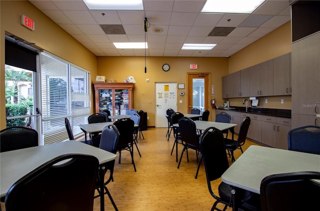 dining space with light hardwood / wood-style floors and a drop ceiling