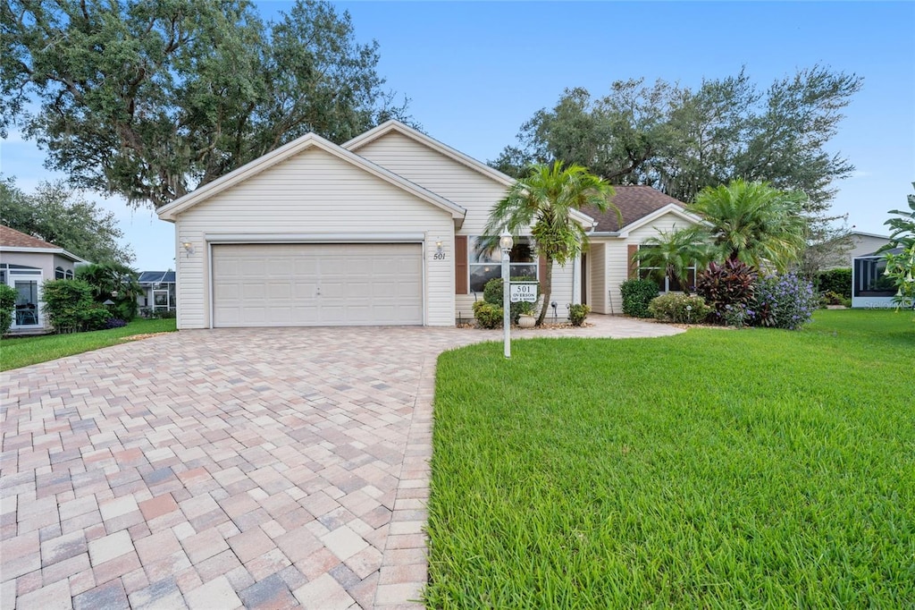 ranch-style home featuring a garage and a front lawn