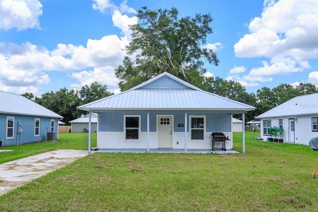 view of front of home with a front lawn, covered porch, and central AC