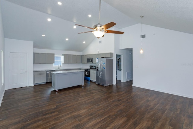 kitchen with high vaulted ceiling, ceiling fan, stainless steel appliances, and dark hardwood / wood-style flooring