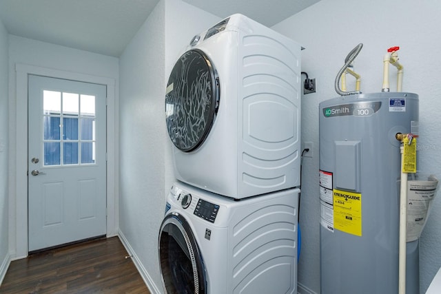 washroom featuring dark wood-type flooring, electric water heater, and stacked washer / dryer