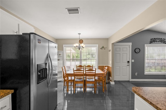 kitchen featuring vaulted ceiling, an inviting chandelier, dark tile patterned floors, stainless steel refrigerator with ice dispenser, and white cabinets