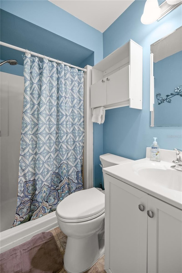 bathroom featuring vanity, toilet, curtained shower, and tile patterned floors