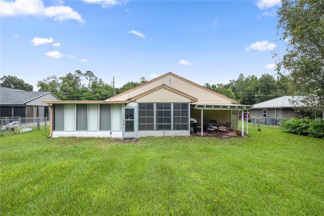 back of house with a sunroom and a yard