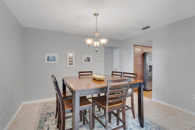 tiled dining area with an inviting chandelier