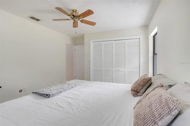 bedroom with ceiling fan and a closet