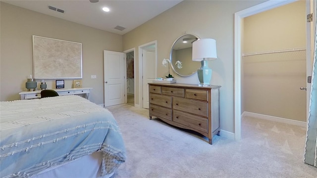 carpeted bedroom with a closet and a spacious closet