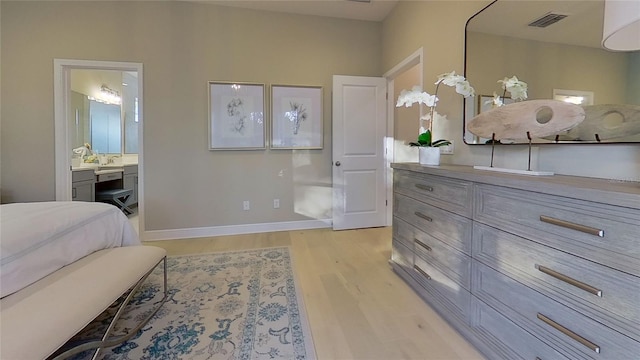 bedroom with light hardwood / wood-style flooring and connected bathroom