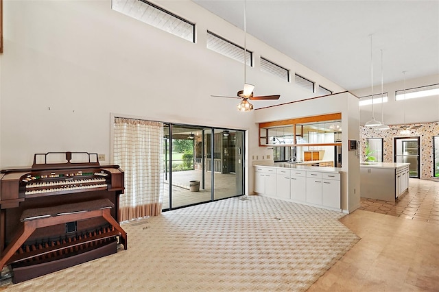 kitchen with white cabinetry, light carpet, ceiling fan, and pendant lighting