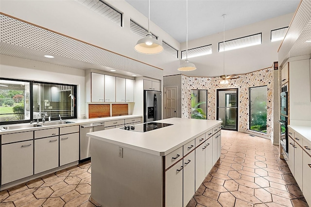 kitchen with white cabinetry, a center island, stainless steel appliances, and decorative light fixtures