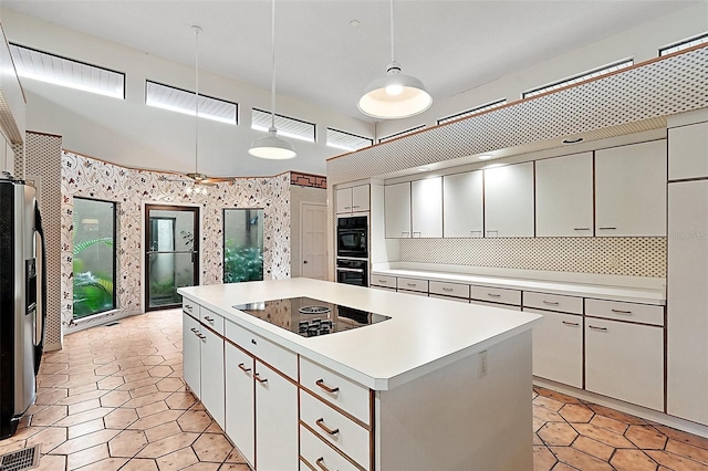 kitchen with black appliances, a center island, white cabinetry, and decorative light fixtures