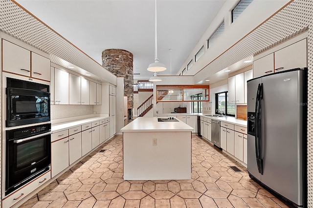 kitchen featuring white cabinets, a center island, sink, and black appliances