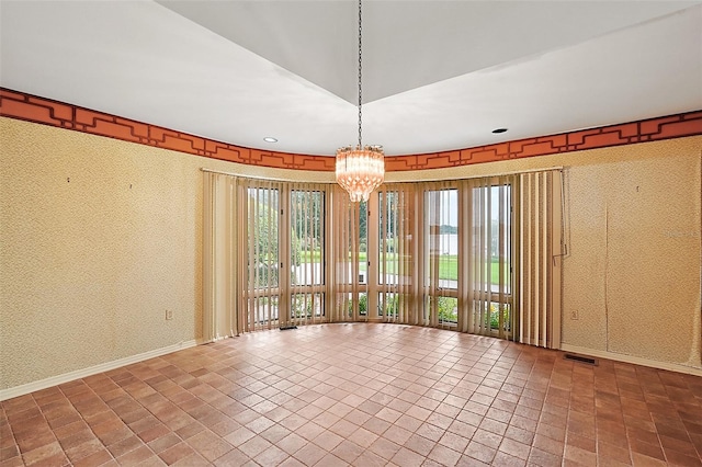 unfurnished room with a notable chandelier