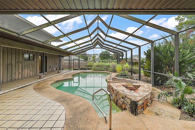 view of swimming pool featuring glass enclosure and a patio area