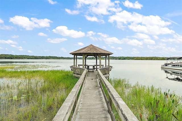 view of dock with a gazebo and a water view