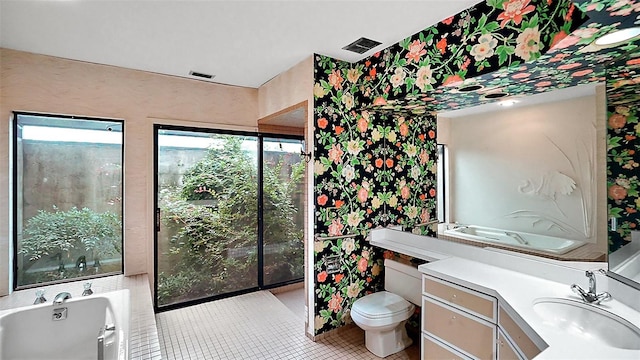 bathroom with vanity, tile patterned flooring, a washtub, and toilet