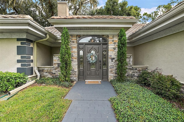 doorway to property featuring a lawn