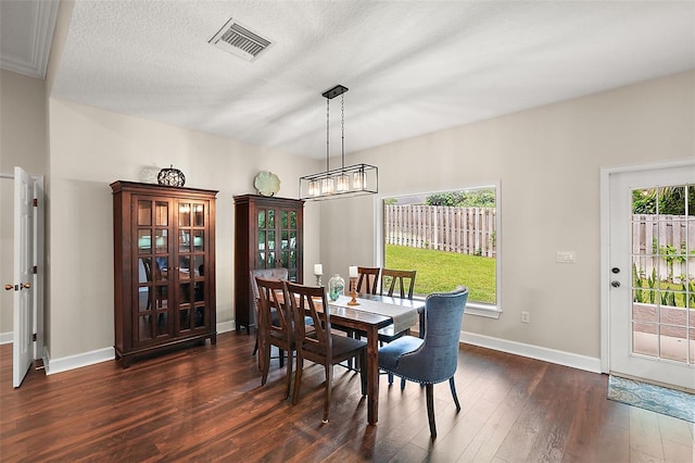 dining room featuring a textured ceiling, dark hardwood / wood-style floors, and a notable chandelier