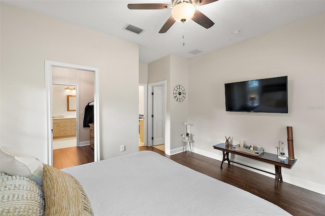 bedroom with ceiling fan, dark hardwood / wood-style floors, and connected bathroom