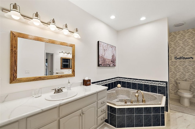 bathroom with toilet, tiled tub, and vanity