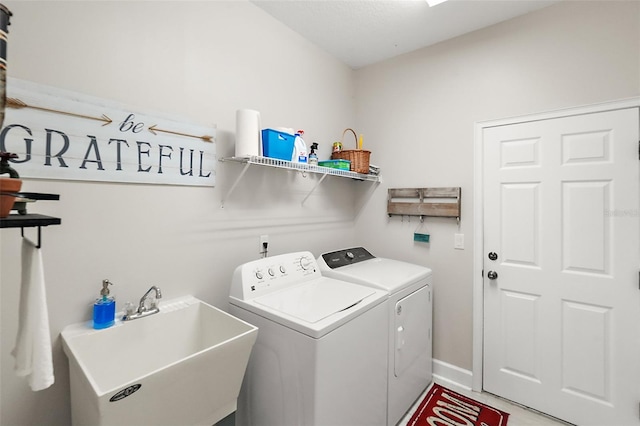 washroom with separate washer and dryer and sink