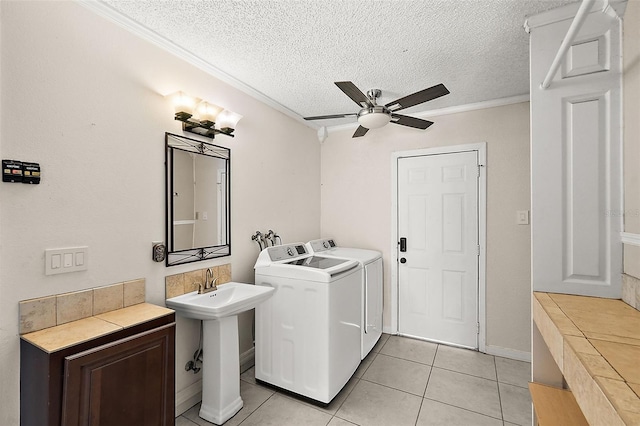 washroom featuring crown molding, light tile patterned floors, a textured ceiling, washing machine and clothes dryer, and ceiling fan