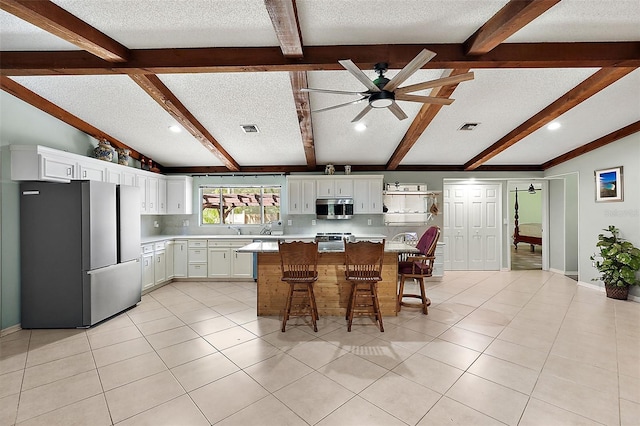 kitchen with a textured ceiling, a center island, and stainless steel appliances