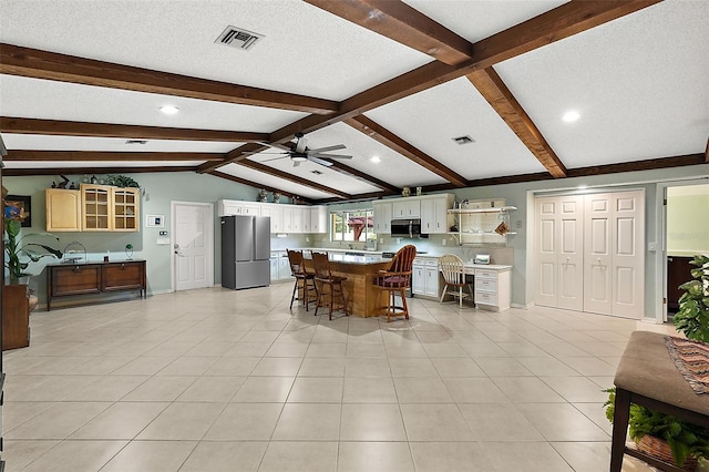 dining room featuring vaulted ceiling with beams, a textured ceiling, light tile patterned flooring, and ceiling fan