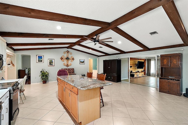 kitchen featuring light stone countertops, vaulted ceiling with beams, a kitchen bar, electric range, and a center island