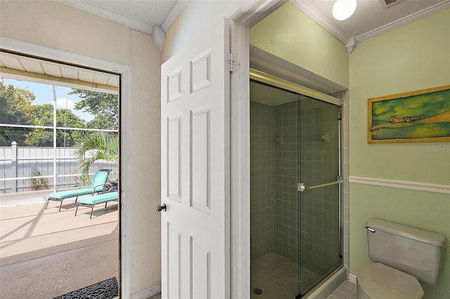 bathroom featuring a shower with door, toilet, and crown molding