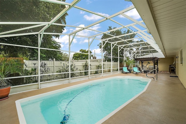 view of swimming pool featuring a patio and glass enclosure