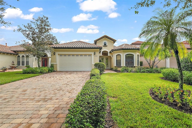 mediterranean / spanish house with a front yard and a garage