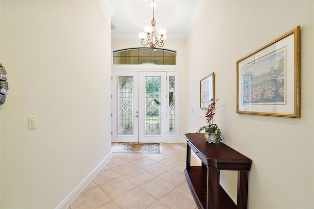 foyer with ornamental molding, french doors, a chandelier, and light tile patterned floors