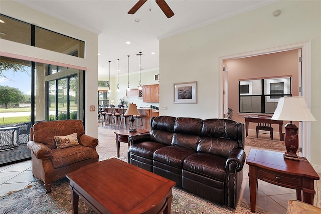 tiled living room featuring ornamental molding and ceiling fan