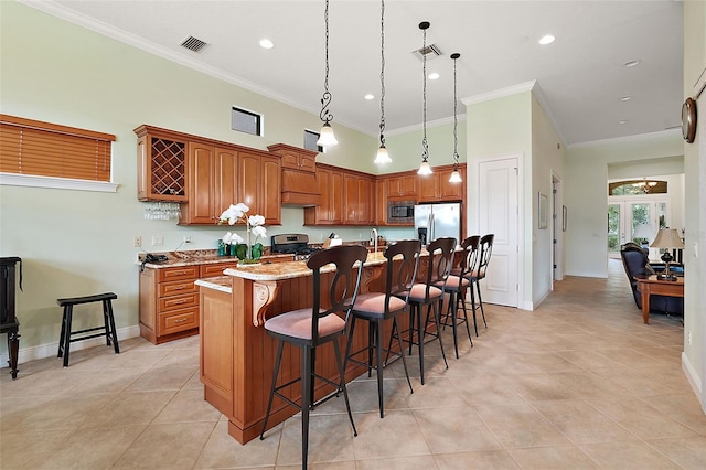 kitchen featuring pendant lighting, crown molding, stainless steel appliances, a kitchen breakfast bar, and a center island with sink