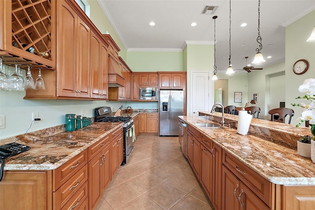 kitchen with a center island with sink, hanging light fixtures, stainless steel appliances, sink, and ornamental molding