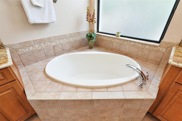 bathroom with tiled bath and vanity