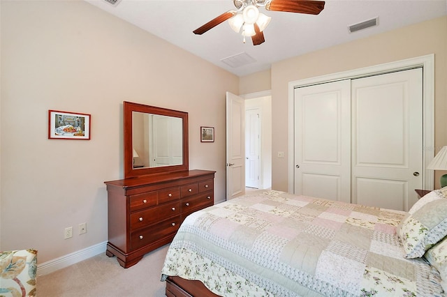 bedroom featuring light colored carpet, ceiling fan, and a closet