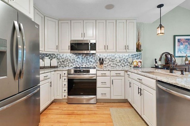 kitchen featuring light hardwood / wood-style flooring, backsplash, stainless steel appliances, sink, and white cabinets