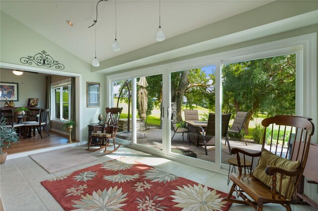 sunroom featuring lofted ceiling and plenty of natural light